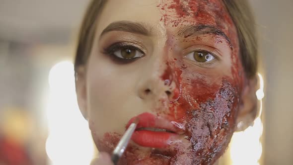 Make-up artist make the girl halloween make up in studio. alt