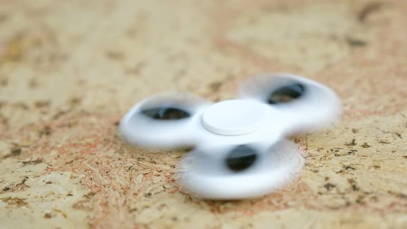 White Hand Spinner To Spin on a Wooden Table