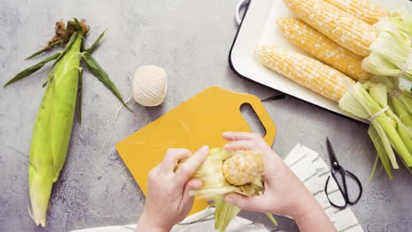 Time lapse. Step by step. Shucking organic corn to make Mexican corn on the cob Elote. alt