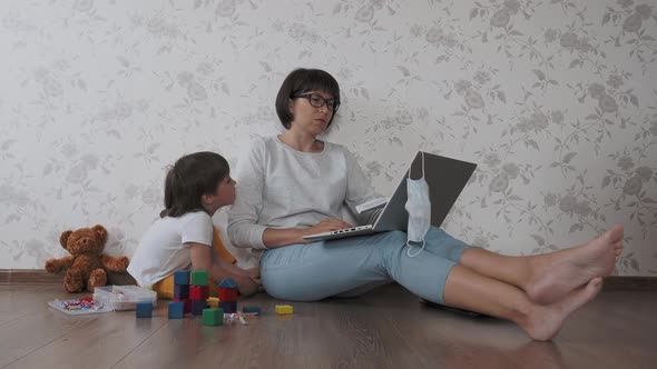 Mom and Son Sit at Home Quarantine Because of Coronavirus COVID19. Mother Remote Works with Laptop alt