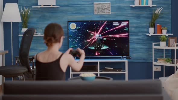Young Woman Holding Wireless Controller Playing Action Space Shooter Disappointed Because Losing alt