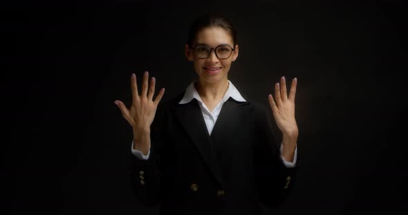 Business Woman Smiles at the Camera and Shows the Number Nine with Her Fingers