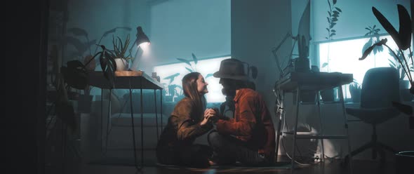 Couple kiss while sitting on the floor alt