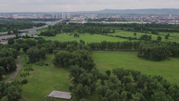 Flight Over a Green Park Overlooking the City alt
