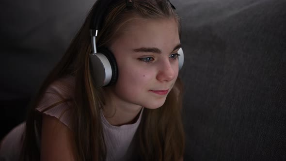 Caucasian Girl with Headphones Relaxing in Front of Her Computer alt