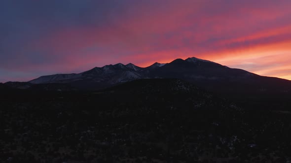 Red And Purple Sunset Sky Over Northern Arizona Mountain Range - Aerial Dolly Out alt