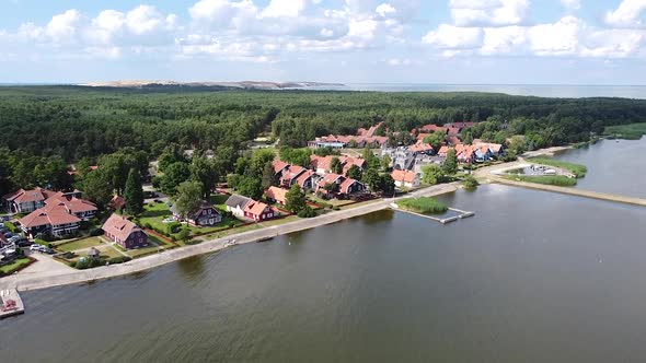 Fly towards resort town of Pervalka on sunny day in Lithuania, Neringa region alt