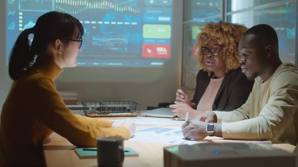 Multiethnic Colleagues Discussing Project at Night Business Meeting alt