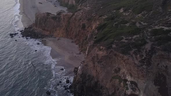 AERIAL: Flight Over Malibu, California View of Beach Shore Line Pacific Ocean at Sunset with alt