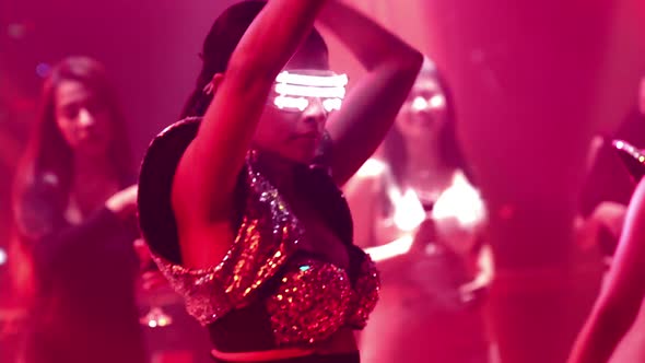 Group of People Dance in Disco Night Club to the Beat of Music From DJ on Stage alt