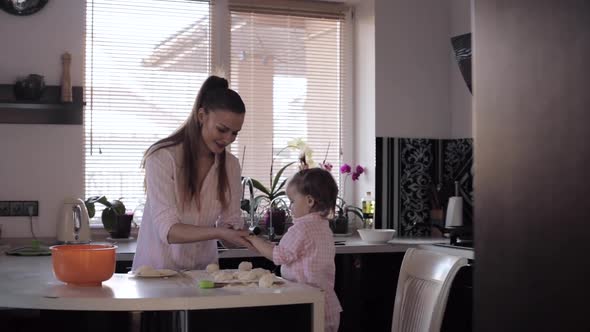 Mother Cooking Together with Little Daughter at Kitchen