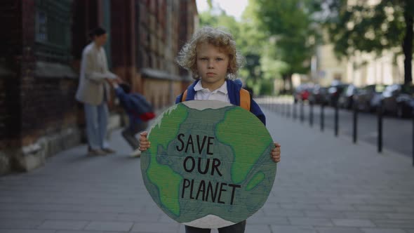 Little Boy Standing Outdoor Against Enviroment Pollution Loooking at Camera alt