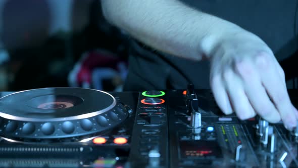 Tracking Shot of a Man DJ Playing with Mixer and Digital Turntables alt