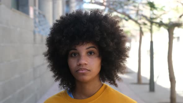 portrait of one young beautiful African or American woman looking at the camera  seriously alt