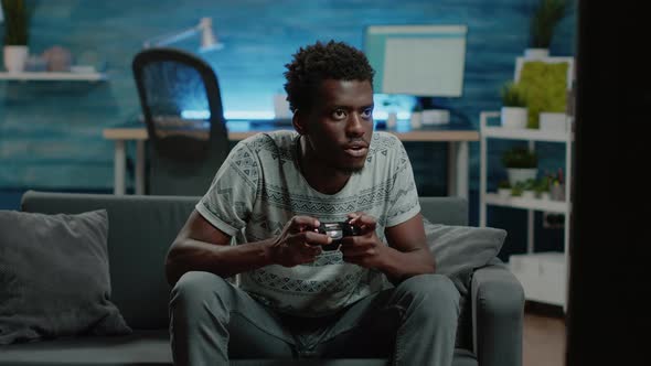 Young Adult Losing at Video Games on TV Console with Joystick alt