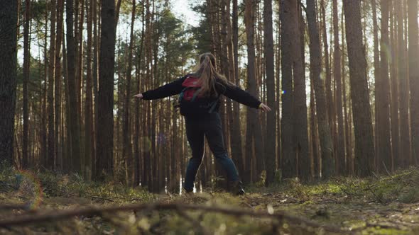 Girl Spinning in the Forest with a Backpack alt