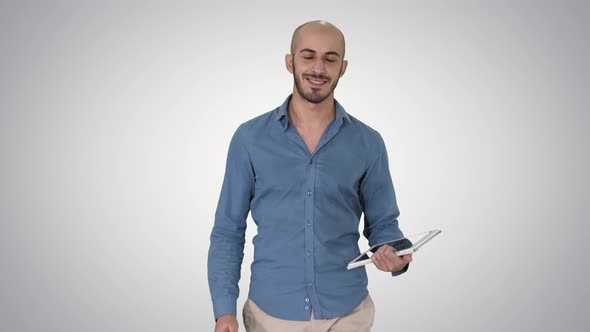 Arab Presenter Walking with Digital Tablet Swiping Pages on It on Gradient Background. alt