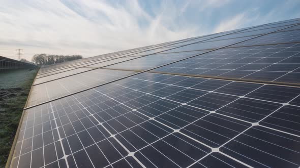 Clouds time lapse reflecting on solar farm solar panels, sustainable energy alt