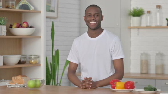 Sporty African Man Smiling at the Camera While Standing in Kitchen alt
