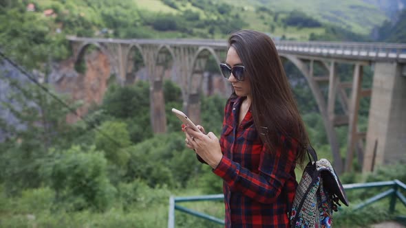 Woman Travel and Using Phone in Mountains