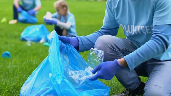 Smiling Volunteer Collecting Rubbish in Park, Pollution Problem, Love to Nature alt