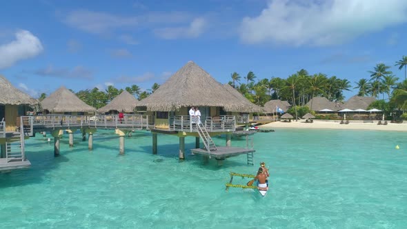 A man and woman couple on a outrigger canoe boat in Bora Bora tropical island alt