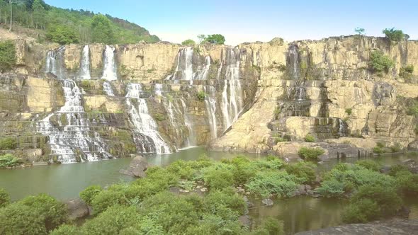 Brown Steep Waterfall Cliffs Lit By Sunset Rays alt
