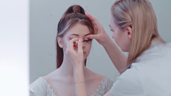 A Makeup Artist Applies Eyelash Shadow To Another Woman