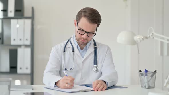 Male Doctor Reading Medical File alt