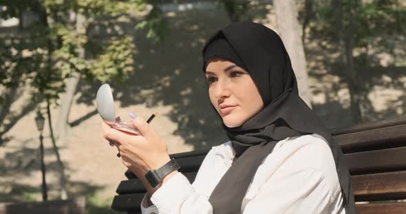 Beautiful Muslim Woman Looking in Mirror in City Park Closeup alt