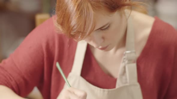 Ceramics Artist Smoothing Surface of Handmade Bowl with Brush and Slip Clay alt
