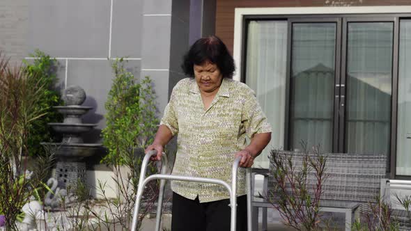 senior woman walking with walker at home