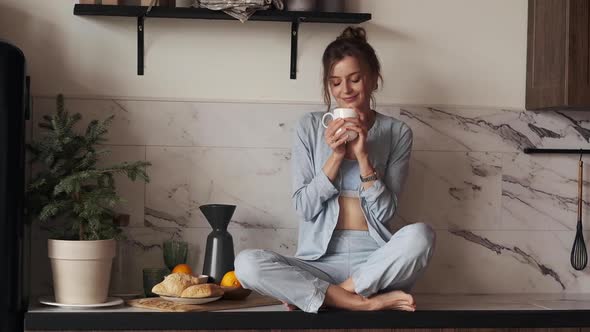 Woman Enjoying Coffee in Kitchen at Xmas.