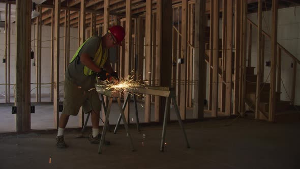 Construction worker grinding metal and making sparks, slow motion