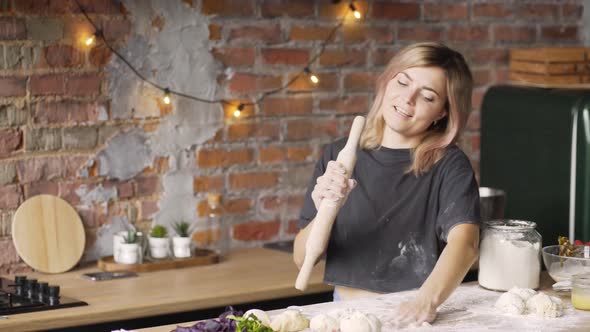 Joyful Lady Dances at Kitchen Table Singing Into Rolling Pin