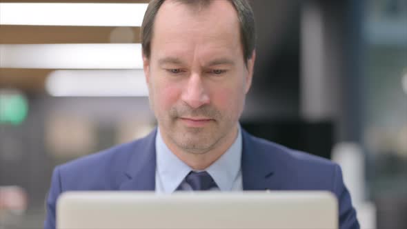 Portrait of Businessman with Laptop Showing Thumbs Up alt