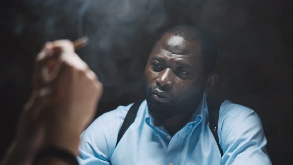 Smoking Suspect with Handcuffs Being Interviewed in Interrogation Room By Police Officer alt