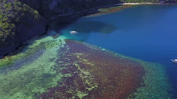 Tourist Boat Floating On Blue Sea Beside The Forested Island In El Nido Philippines alt