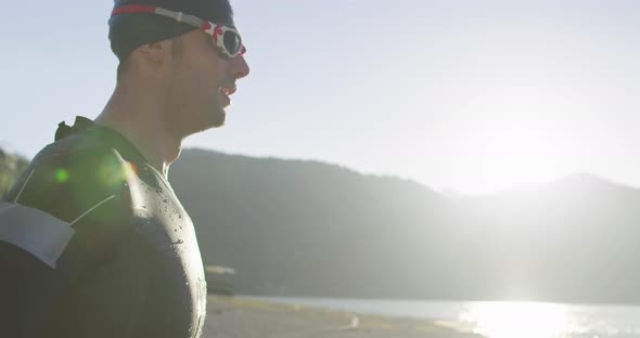 Slow Motion Closeup Portrait of Triathlon Athlete Getting Ready and Prepare Goggles Hat and Wetsuit alt