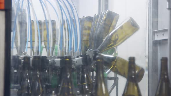 Red Wine bottles on a conveyor belt in a wine bottling factory. alt