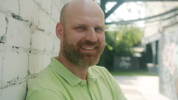 Closeup Portrait of Attractive Guy Turning to Camera and Smiling Outdoors on Sunny Summer Day alt