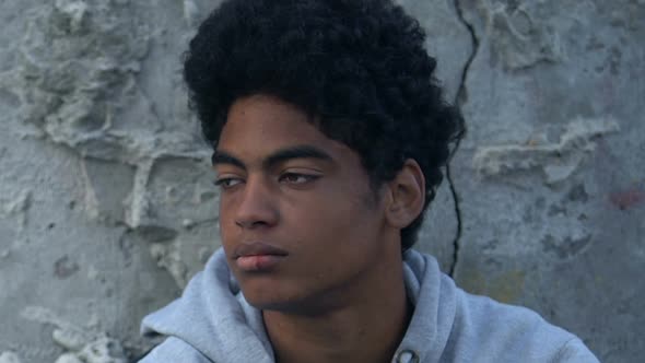 Mixed-race male teenager with bruised face, breathing to calm down alt