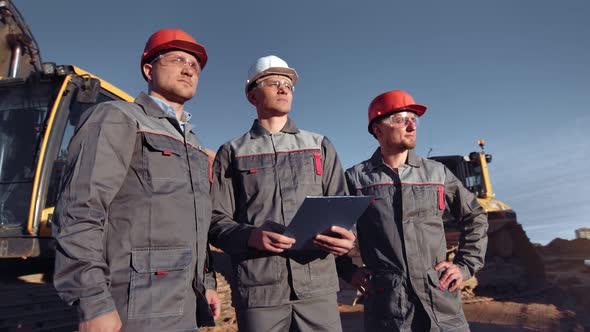 Team of Professional Male Builder Worker in Construction Site at Sunset Medium Shot alt