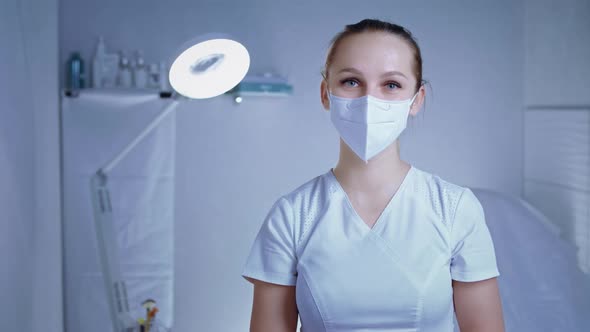 Portrait of Young Caucasian Female Surgeon or Doctor Standing in Operating Room and Smiling at