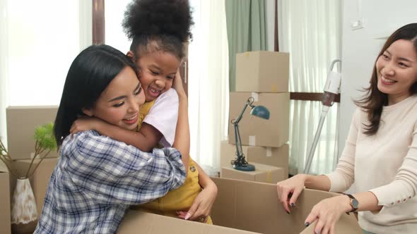 LGBT Family Unpacking Boxes In New Home On Moving Day. alt