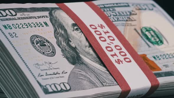 Bundles of Dollars Rotate on Black Background alt