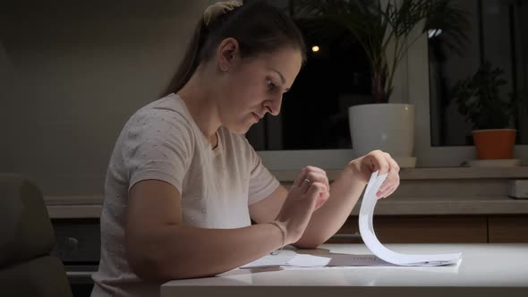 Stressed Young Woman Having Problems Sitting at Night Reading Documents alt