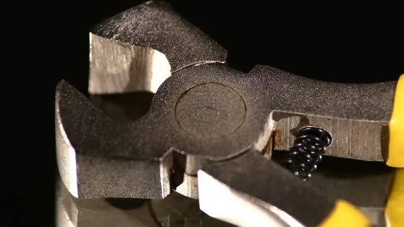 Part of Wire Cutters with Yellow, Gray Handle on Black, Reflection, Close Up, Rotation alt
