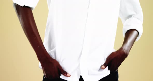 Androgynous man posing against yellow background alt