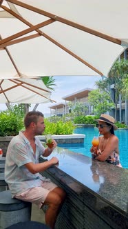Couple Men and Women Drinking Cocktails By the Bar of a Tropical Pool During Vacation alt